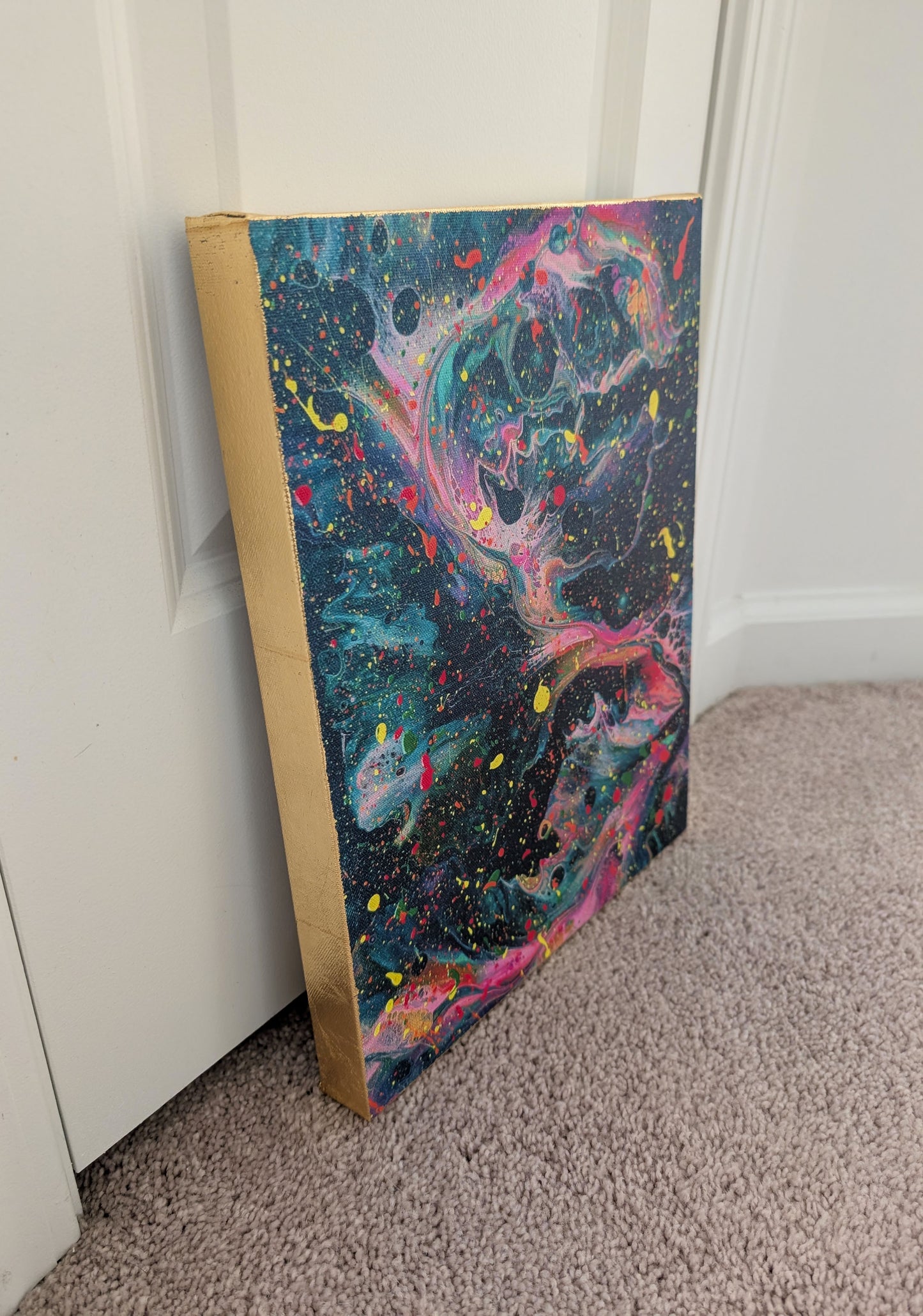Side angle of the dark abstract fluid art canvas showing the hand-applied gold leaf on the edges and the vibrant swirling colors on the front.