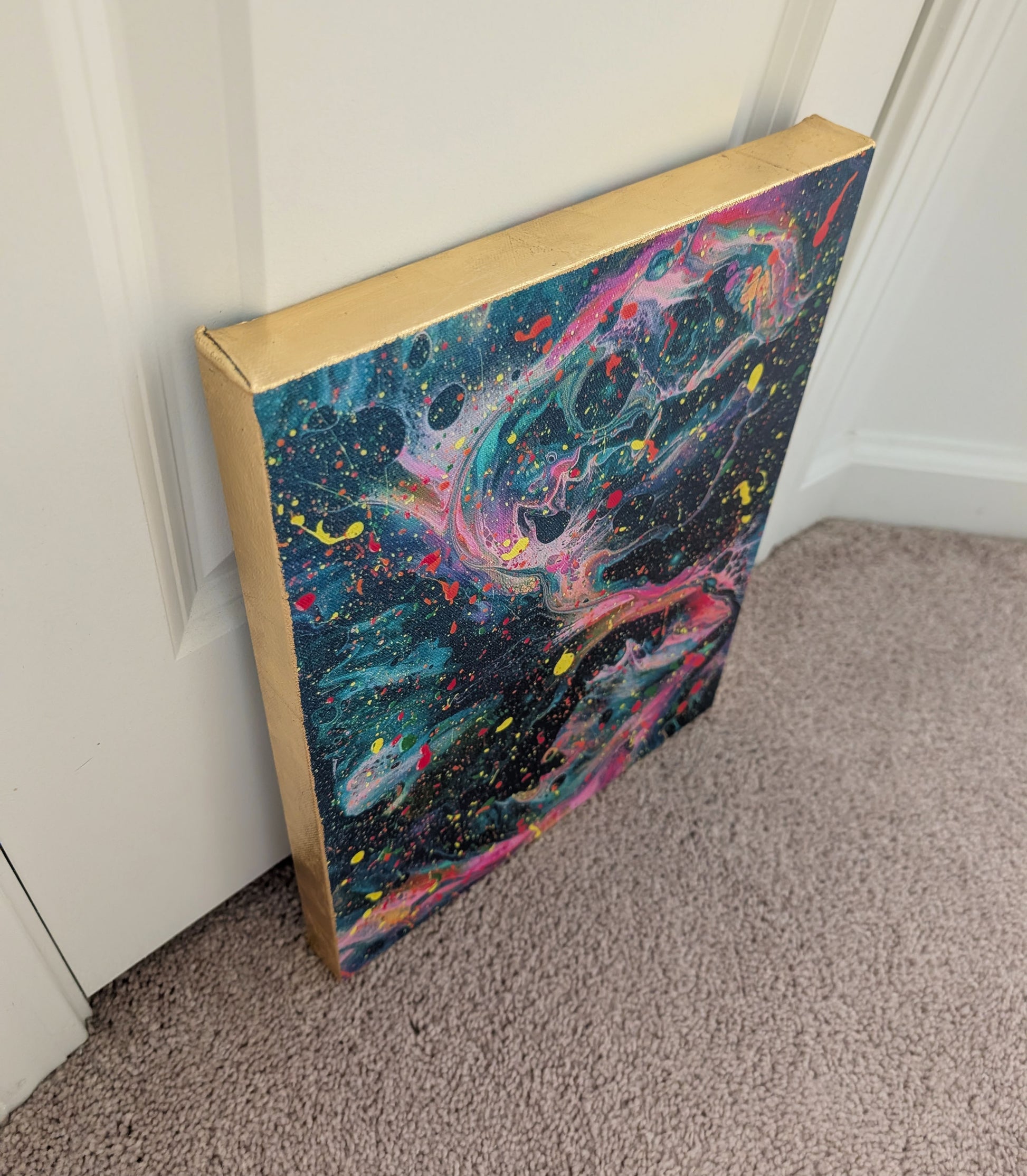 Angled side view of the dark fluid art canvas, highlighting the textured gold leaf edge and the layered, colorful movement across the painting’s surface