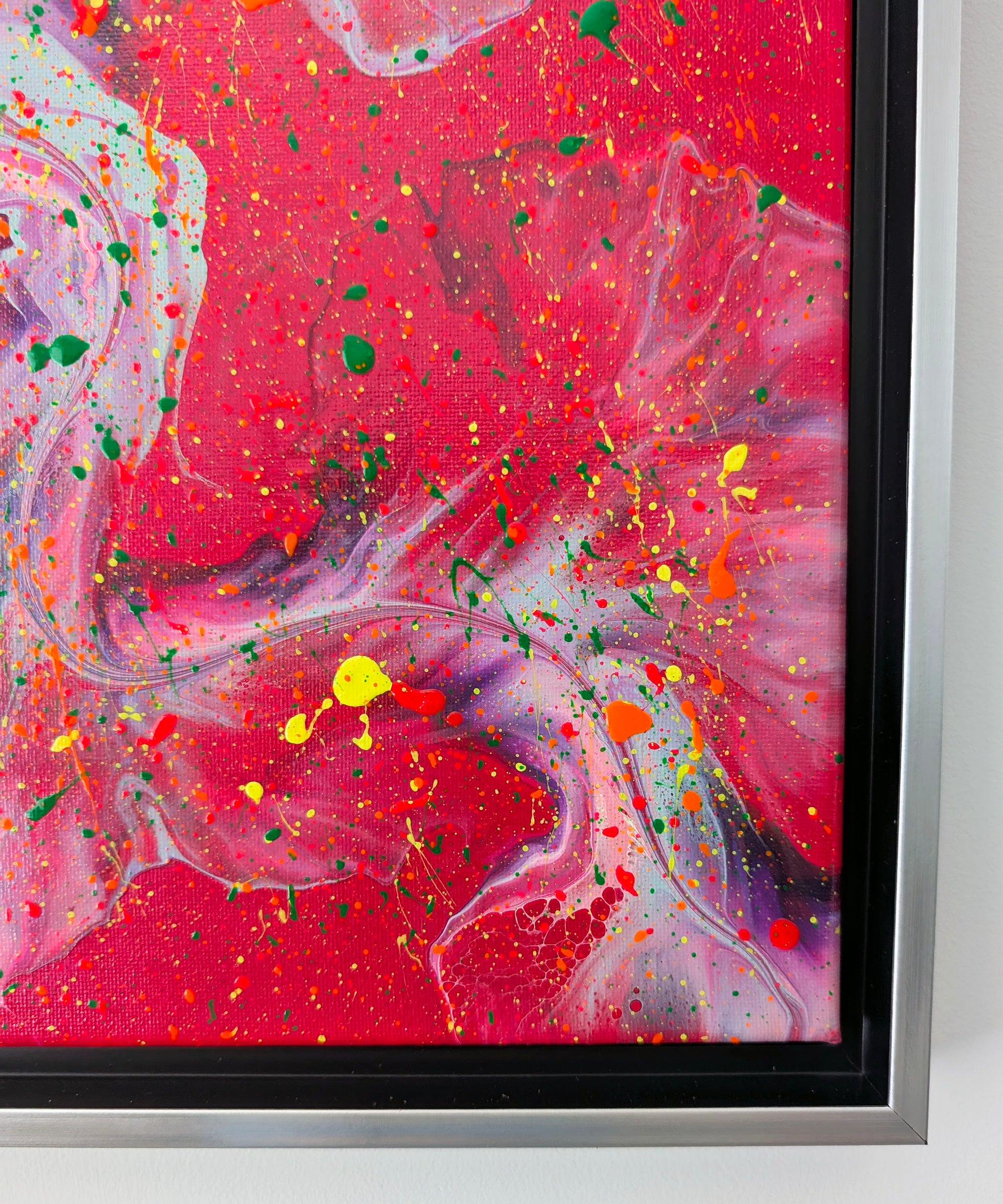 Macro detail of the lower right corner, where intricate swirls of lavender and deep red meet, overlaid by bold splashes of bright yellow, orange, pink, and green.