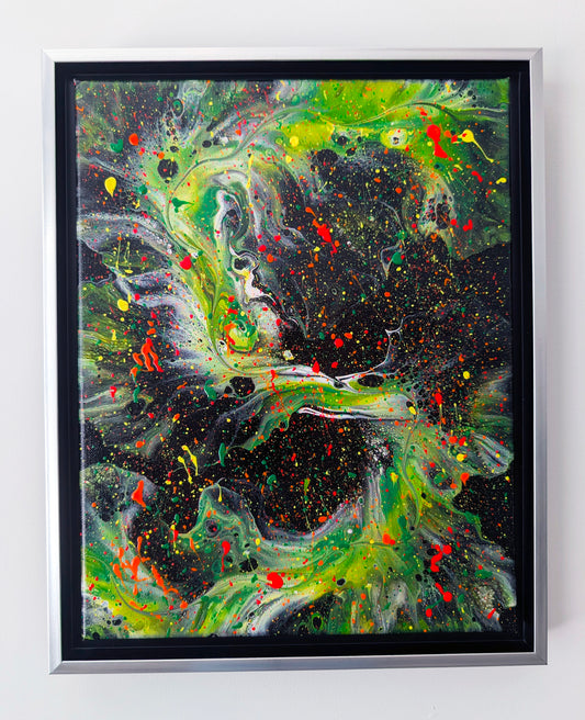 Abstract acrylic fluid painting with vibrant green, yellow, and red splatters swirling over a deep black background. The texture features dynamic movement and speckled layers, framed in silver with a black inset.
