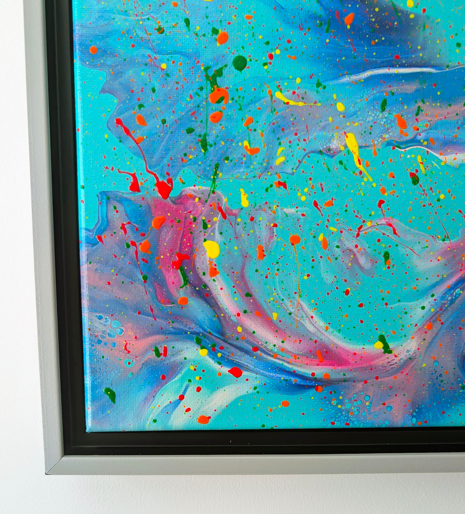 Detail of the bottom left corner, highlighting soft ribbons of pink, lavender, and blue against turquoise, interspersed with small multicolor specks and larger neon drips.