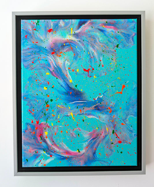 A framed abstract fluid art painting with swirling layers of teal, blue, purple, and pink on a vibrant turquoise background. Neon splatters of red, yellow, orange, and green create a dynamic, energetic feel. The silver floating frame adds a polished edge to the expressive piece.